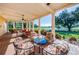 Covered patio with stone columns, brick flooring, and outdoor seating overlooking garden at 1012 Tuscany Dr, Trinity, FL 34655