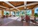 Covered outdoor patio with brick flooring, ceiling fans, and comfortable seating area at 1012 Tuscany Dr, Trinity, FL 34655