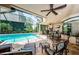 Outdoor pool area featuring a screened-in patio with seating and a grill at 1012 Tuscany Dr, Trinity, FL 34655