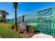 Well-maintained tennis court with green fencing, mature landscaping, and posted court rules at 1012 Tuscany Dr, Trinity, FL 34655