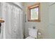 Bathroom with toilet, window, and patterned wall paper at 10193 Wallien Dr, Brooksville, FL 34601