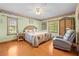 Comfortable bedroom with hardwood floors, floral wallpaper border, and a cozy rattan bed at 10193 Wallien Dr, Brooksville, FL 34601