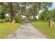 Long driveway lined with mature trees leading up to the house, complemented by manicured lawns at 10193 Wallien Dr, Brooksville, FL 34601