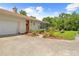 Exterior house featuring landscaped garden, red door, and a garage at 10193 Wallien Dr, Brooksville, FL 34601