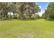 Large front lawn with mature trees providing shade and character to the property's landscape at 10193 Wallien Dr, Brooksville, FL 34601