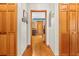 A hallway leads to a kitchen, featuring hardwood floors and a series of wooden closet doors at 10193 Wallien Dr, Brooksville, FL 34601