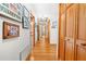 Bright hallway with hardwood floors, wooden closet doors, and framed pictures on the white wall at 10193 Wallien Dr, Brooksville, FL 34601