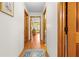 Bright hallway with hardwood floors connecting different rooms in the house with charming rug at 10193 Wallien Dr, Brooksville, FL 34601