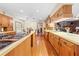 Extended kitchen space with island cooktop, classic wood cabinetry, and plenty of room for dining at 10193 Wallien Dr, Brooksville, FL 34601