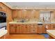 Traditional style kitchen featuring wood cabinets, appliances, and vintage wallpaper for a warm ambiance at 10193 Wallien Dr, Brooksville, FL 34601