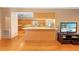Open kitchen with breakfast bar featuring wood cabinets, a kitchen island, and hardwood flooring at 10193 Wallien Dr, Brooksville, FL 34601