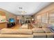 Cozy living room features a stone fireplace, ceiling fan, and a comfortable leather sectional sofa at 10193 Wallien Dr, Brooksville, FL 34601