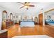Hardwood floor main bedroom showcasing a ceiling fan, dressers, and natural light at 10193 Wallien Dr, Brooksville, FL 34601