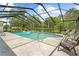 Inviting screened-in pool with patio seating and lush landscaping at 10193 Wallien Dr, Brooksville, FL 34601