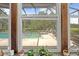 View of the screened pool area with outdoor seating from the sunroom window; beautiful landscaping at 10193 Wallien Dr, Brooksville, FL 34601