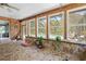 Cozy sunroom featuring stone accents, wood trim, and views of the screened-in pool and patio at 10193 Wallien Dr, Brooksville, FL 34601