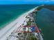 An aerial view of a waterfront property with a home outlined in red, located on a sandy stretch of land at 1114 Mandalay Pt, Clearwater Beach, FL 33767