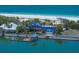 Aerial view of a beautiful blue roof home, dock and boat lift along the turquoise waterfront at 1114 Mandalay Pt, Clearwater Beach, FL 33767