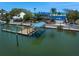 Waterfront home with a private boat dock and lift, complemented by lush tropical landscaping and beach access at 1114 Mandalay Pt, Clearwater Beach, FL 33767