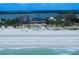 Beachfront home with blue roof, surrounded by lush greenery, and offering panoramic views of the water at 1114 Mandalay Pt, Clearwater Beach, FL 33767