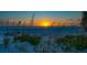Tranquil beach sunset with golden sunlight reflecting on gentle waves and native beach grasses at 1114 Mandalay Pt, Clearwater Beach, FL 33767