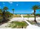 Breathtaking view from the property, showcasing a pristine white sand beach, clear blue waters, and lush tropical vegetation at 1114 Mandalay Pt, Clearwater Beach, FL 33767