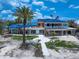 Stunning waterfront home featuring a blue tile roof, second-story balcony, and beachfront access at 1114 Mandalay Pt, Clearwater Beach, FL 33767
