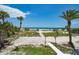 Path leading to the beach, lined with lush palm trees and clear views of the ocean at 1114 Mandalay Pt, Clearwater Beach, FL 33767