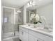 Bright bathroom with double sinks, modern fixtures, and a glass shower enclosure at 11739 Blackbrook Ct, Seffner, FL 33584
