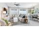 Bright living room featuring modern furniture, large windows, and a contemporary ceiling fan at 11749 Blackbrook Ct, Seffner, FL 33584
