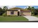 Charming single-story home with a neutral color palette, well-manicured lawn, and a two-car garage at 1182 Orlando Blvd, Port Charlotte, FL 33952