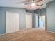 Bright bedroom with a ceiling fan, carpet, and ample closet space for storage at 12464 Berkeley Square Dr, Tampa, FL 33626