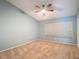 Cozy bedroom featuring carpet, a ceiling fan, a window with blinds, and a fresh blue paint at 12464 Berkeley Square Dr, Tampa, FL 33626