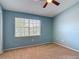 Guest bedroom with natural light, window, ceiling fan, carpet, and views of the neighborhood at 12464 Berkeley Square Dr, Tampa, FL 33626