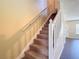 Carpeted staircase with white handrail and balusters that leads to the upper level of the home at 12464 Berkeley Square Dr, Tampa, FL 33626