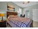 Bedroom features a bed with plaid bedspread, workstation, and ensuite bathroom at 12918 Tar Flower Dr., Tampa, FL 33626