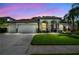 Charming single-Gathering home with a three-car garage, well-manicured lawn, and stone accents at 12918 Tar Flower Dr., Tampa, FL 33626