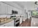 Bright kitchen with stainless double oven, granite countertops, white cabinets and adjacent dining area at 12918 Tar Flower Dr., Tampa, FL 33626