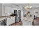 Bright kitchen with granite countertops, stainless steel appliances, white cabinets, and a modern island dining area at 12918 Tar Flower Dr., Tampa, FL 33626