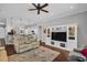 Open-concept living room with hardwood floors, a ceiling fan, and a media center at 12918 Tar Flower Dr., Tampa, FL 33626
