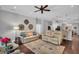 Cozy living room with hardwood floors, ceiling fan, and a view to the kitchen with island chairs at 12918 Tar Flower Dr., Tampa, FL 33626