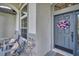 Close up of a charming front porch with seating and a welcoming wreath on the front door at 12918 Tar Flower Dr., Tampa, FL 33626