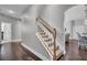 Elegant staircase featuring hardwood floors, carpeted steps, and white railings, offering a stylish transition between levels at 12918 Tar Flower Dr., Tampa, FL 33626