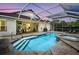 Relaxing screened-in pool with a spa and ample patio space, perfect for outdoor entertaining as the sun sets at 12918 Tar Flower Dr., Tampa, FL 33626