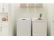Efficient laundry room with white washer and dryer, upper cabinets, and ample storage space at 13118 Empress Jewel Trl, Parrish, FL 34219