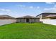 Spacious backyard featuring lush green lawn, privacy fence, and modern home exterior at 13235 Palmerston Rd, Riverview, FL 33579