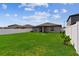 Expansive backyard with green lawn, bordered by a white fence, and house exterior at 13235 Palmerston Rd, Riverview, FL 33579