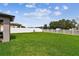 Spacious backyard with healthy green lawn, framed by a white fence under a clear blue sky at 13235 Palmerston Rd, Riverview, FL 33579