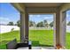 View of a well-manicured backyard from under a covered patio and featuring a lush green lawn at 13235 Palmerston Rd, Riverview, FL 33579