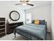 Comfortable bedroom with a metal bed frame, dark dresser, and modern round mirror at 13235 Palmerston Rd, Riverview, FL 33579